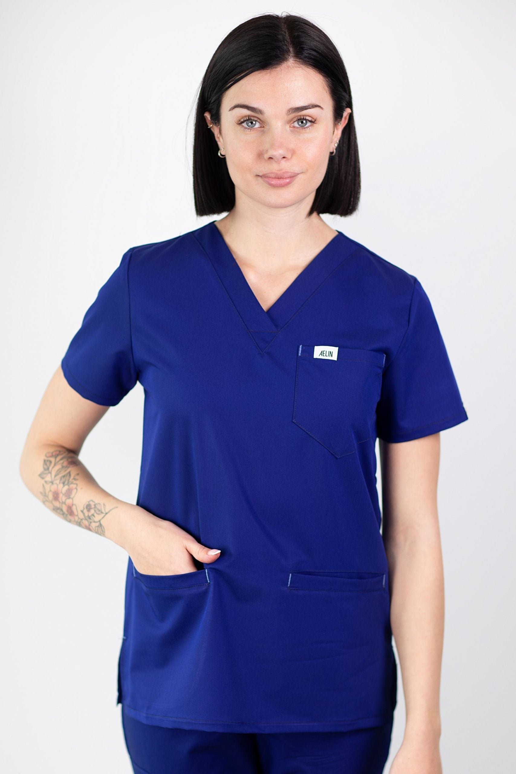 Femme en tunique médicale bleu royal de qualité avec manches courtes et col V