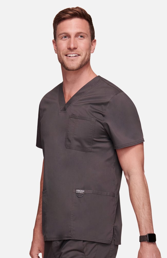 Top de médecin gris porté par un professionnel de santé, offrant des poches pratiques