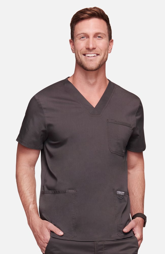 Homme en tenue médicale gris foncé souriant avec poches et calot médical