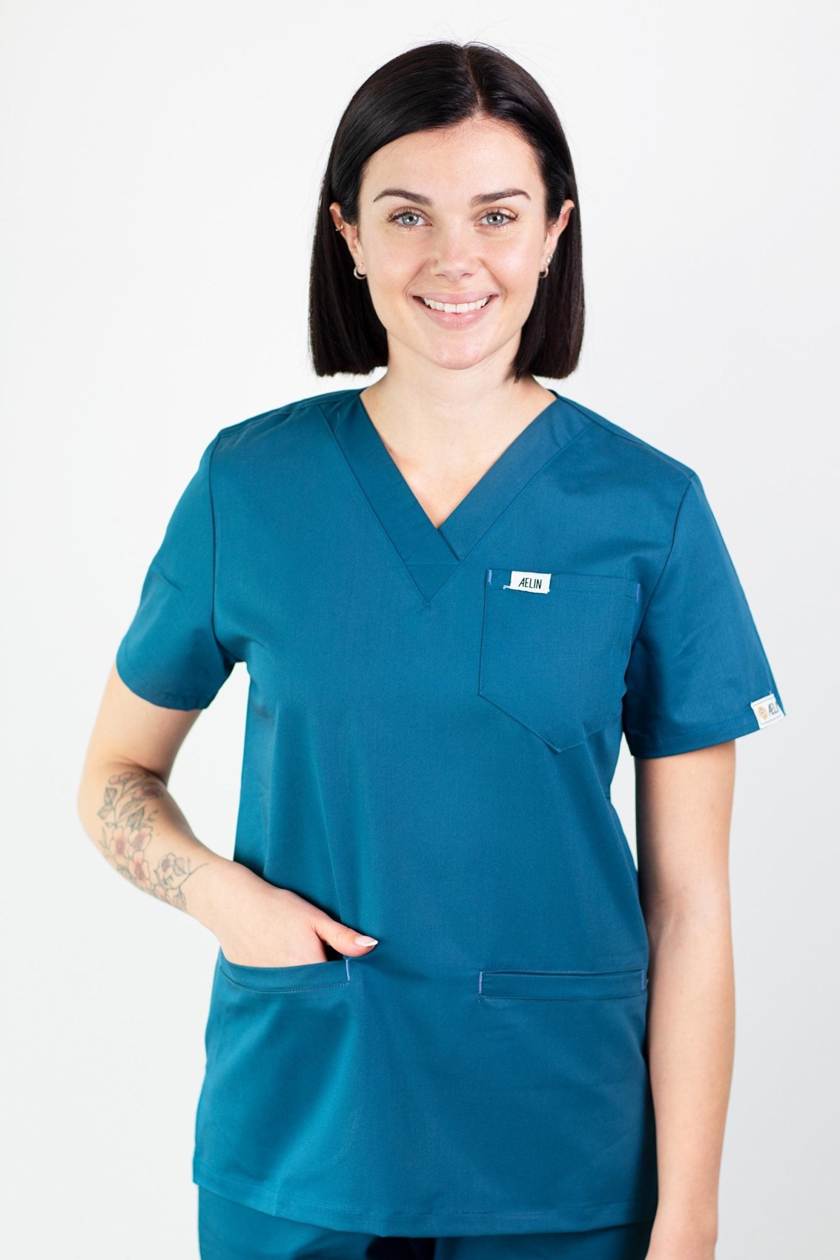 Femme en tunique médicale teal de qualité avec col V et manches courtes