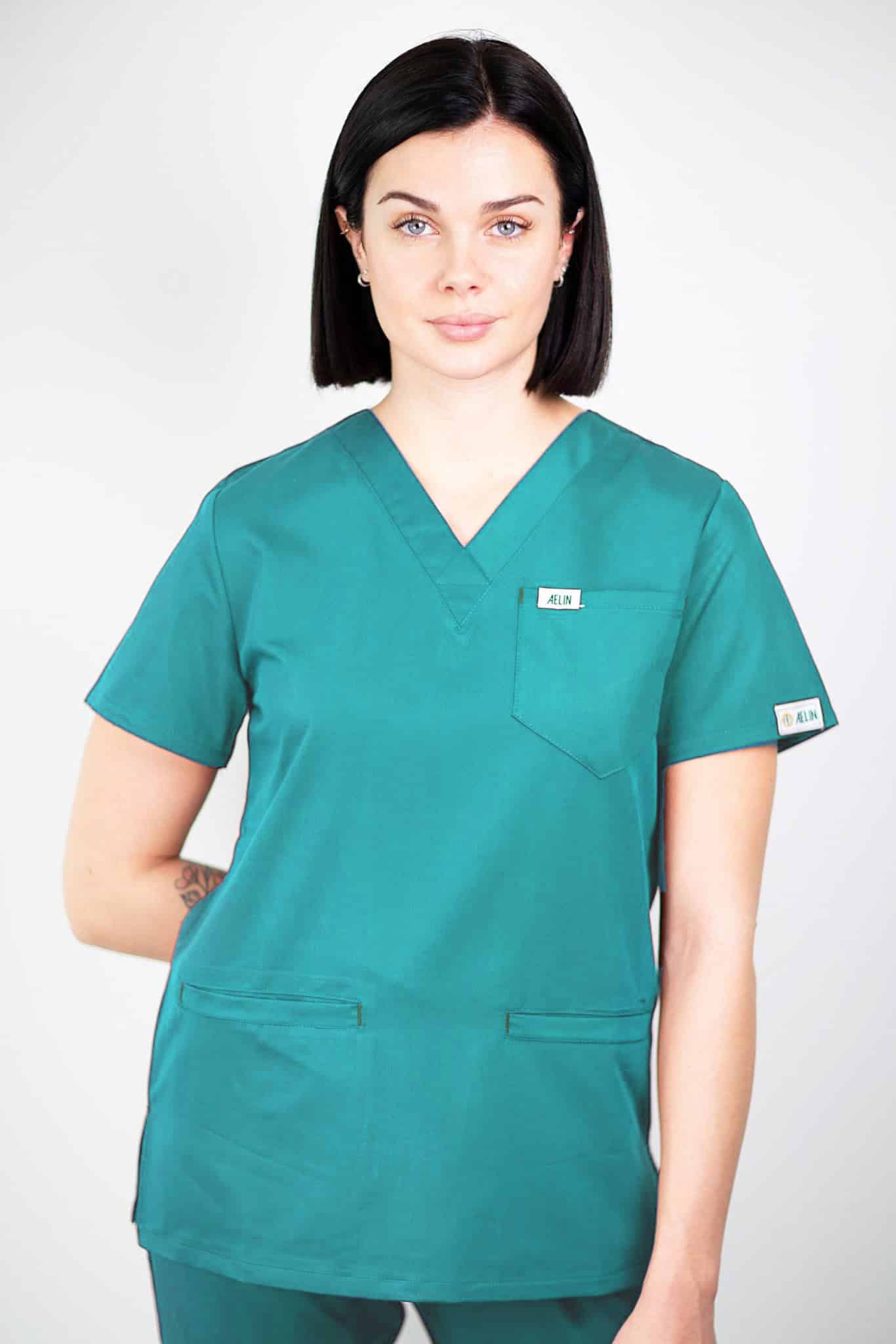 Femme en tunique médicale teal de qualité avec col V et poche poitrine