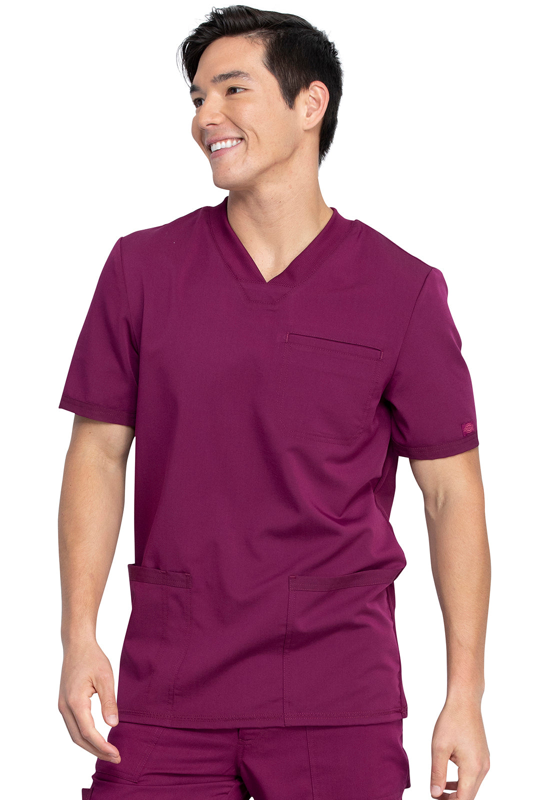 Tunique médicale maroon Balance by Dickies® portée par une personne souriante avec poches plaquées