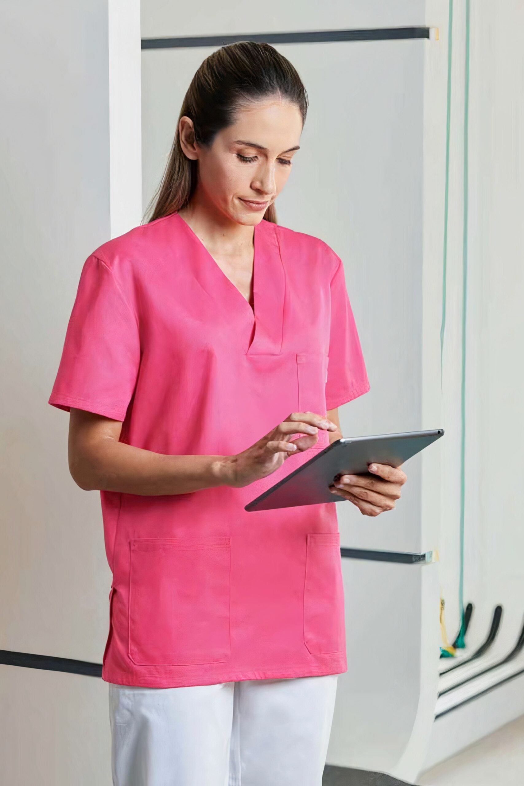 Personnel de santé en uniforme rose utilisant un tab facilement avec coupe unisexe
